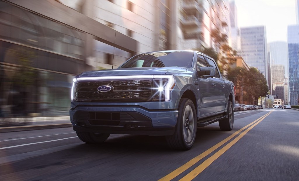 Blue 2022 Ford F-150 Lightning, which could be the best electric pickup truck, driving on a street