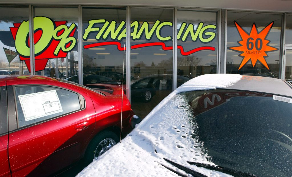  "Zero-Percent Financing For 60 Months" signage is displayed on a window at the Dodge World automobile dealership.