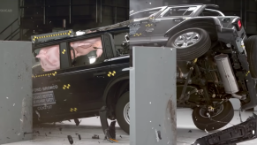 The Ford Bronco and Jeep Wrangler crash test lined up next to each other showing the Jeep mostly off the ground while the Bronco is on all four.