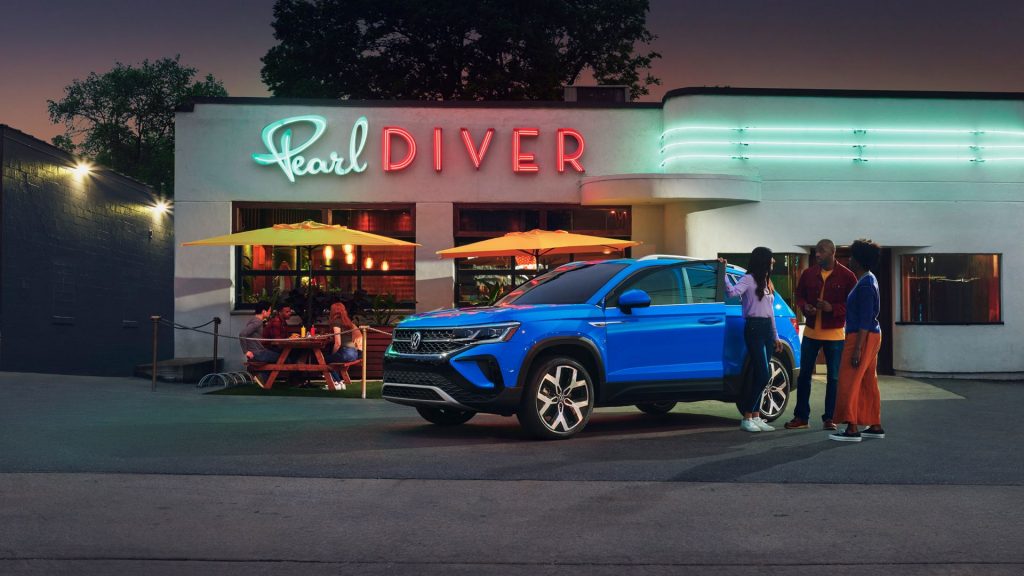 Dusk Blue Metallic 2022 Volkswagen Taos parked near a restaurant