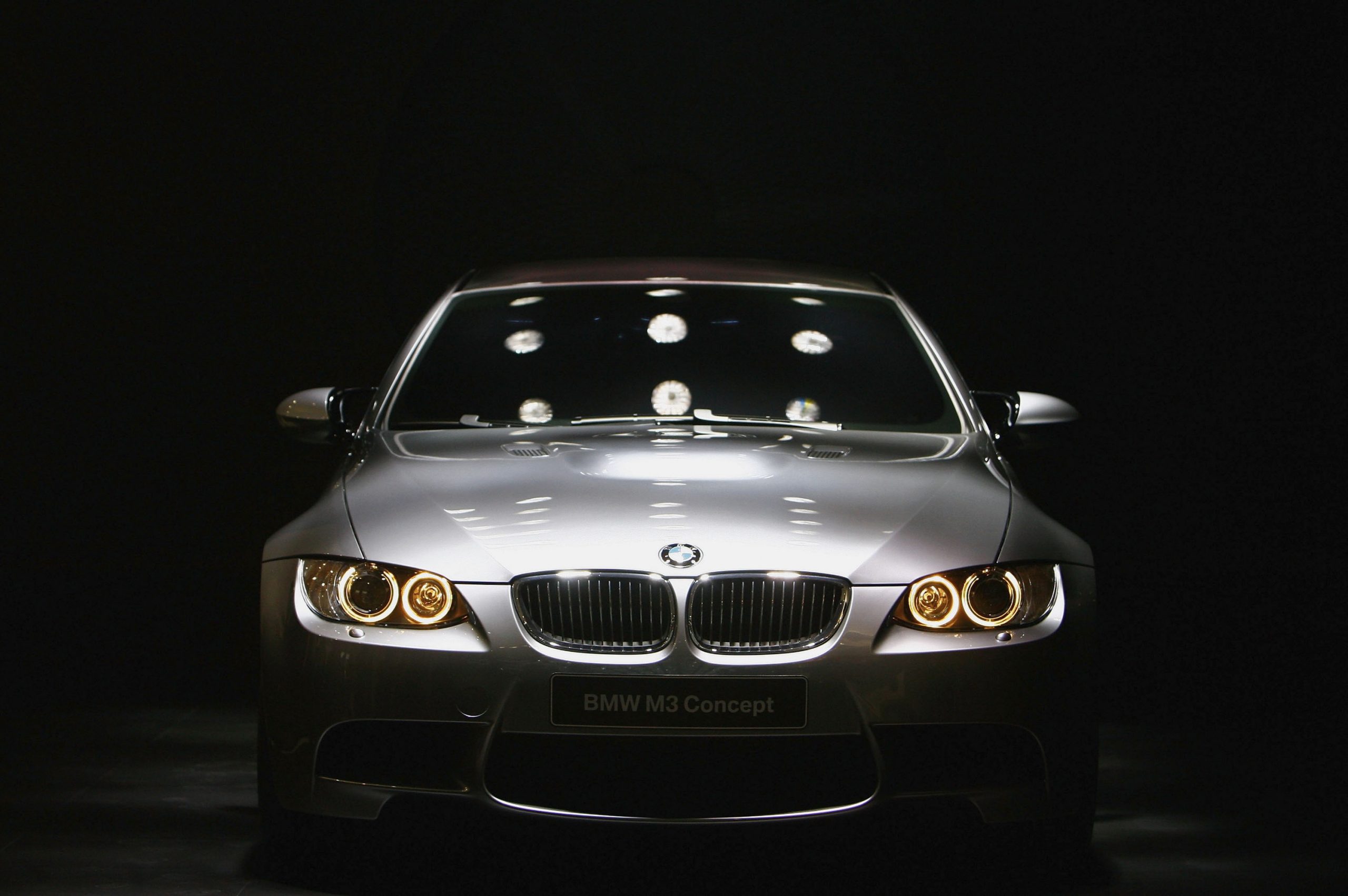 A silver E92 BMW M3 shot from the front surrounded by shadow