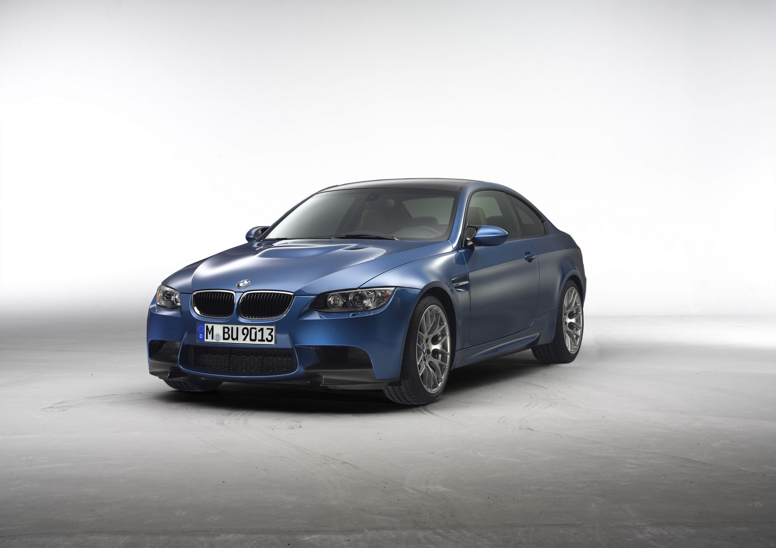 A dark blue E92 BMW M3 sports car shot from the front 3/4 in a photo booth