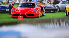 A red Ferrari Enzo at a fancy car show.