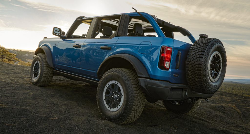 A blue 2021 Ford Bronco is driving uphill. 