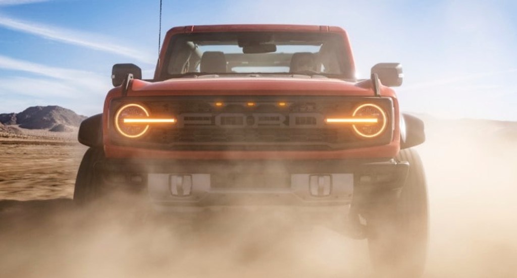 A red Ford Bronco Raptor off-road SUV in the desert.
