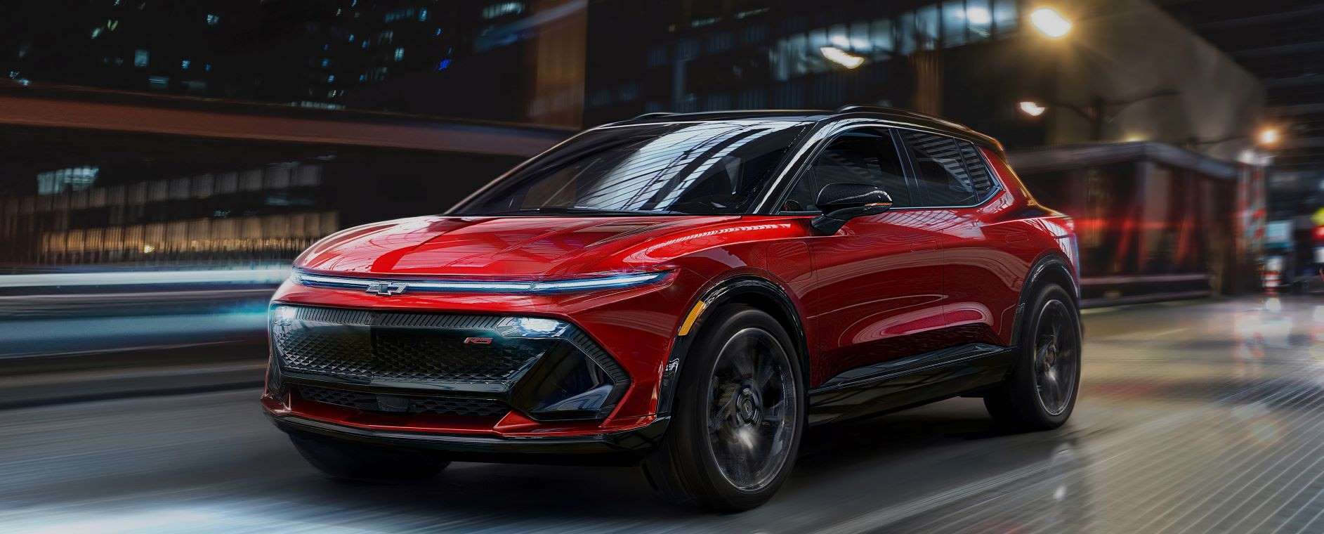 Front view of red 2024 Chevy Equinox EV driving across a bridge