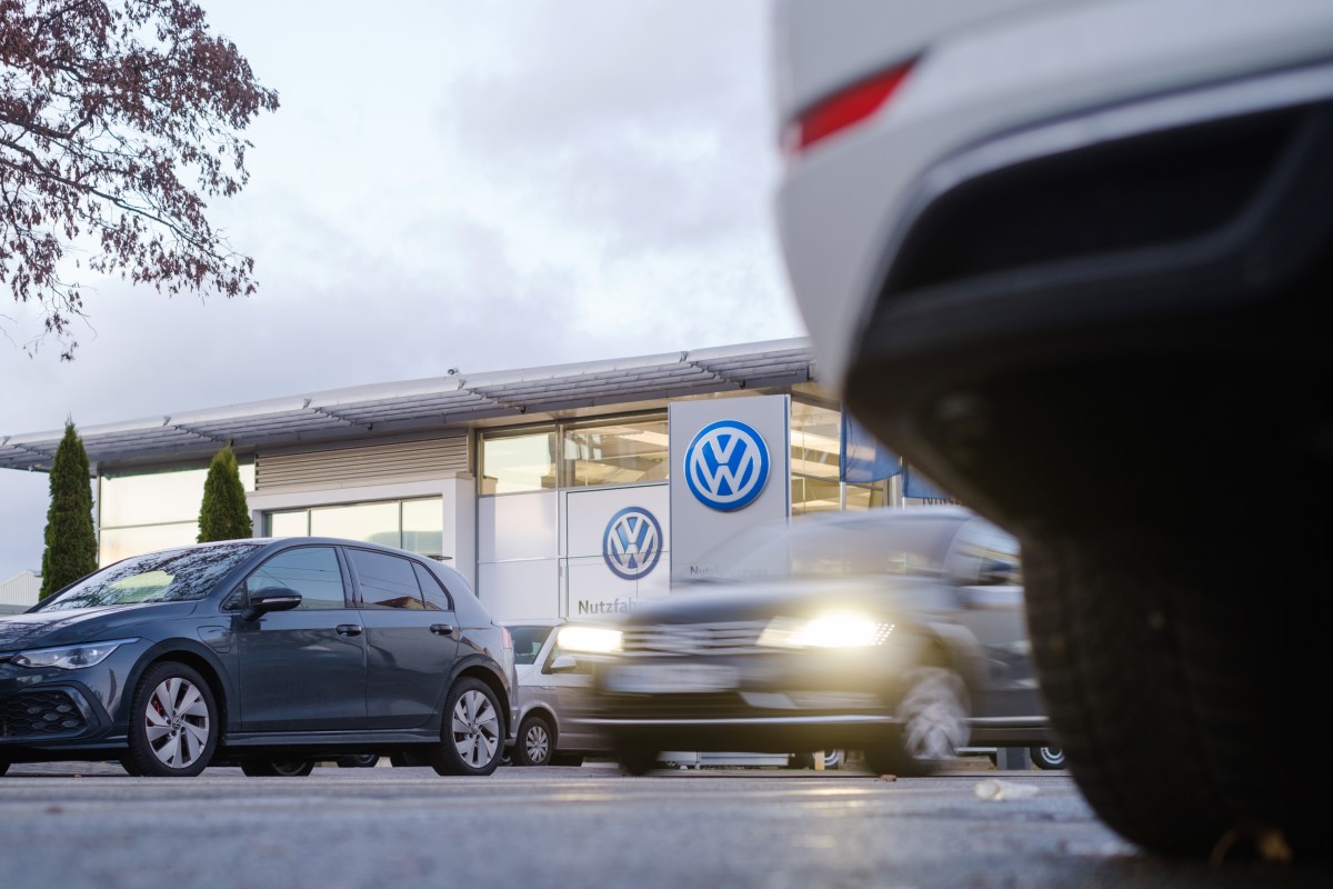 An exterior view of a Volkswagon dealership with cars in front.