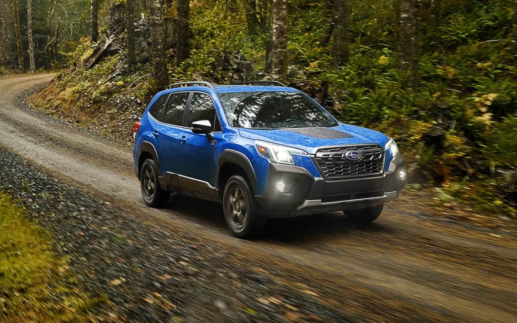 Geyser Blue 2022 Subaru Forester driving on a dirt road, which trim should you buy?