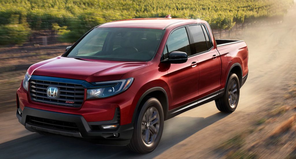 A red 2022 Honda Ridgeline is driving on the road.
