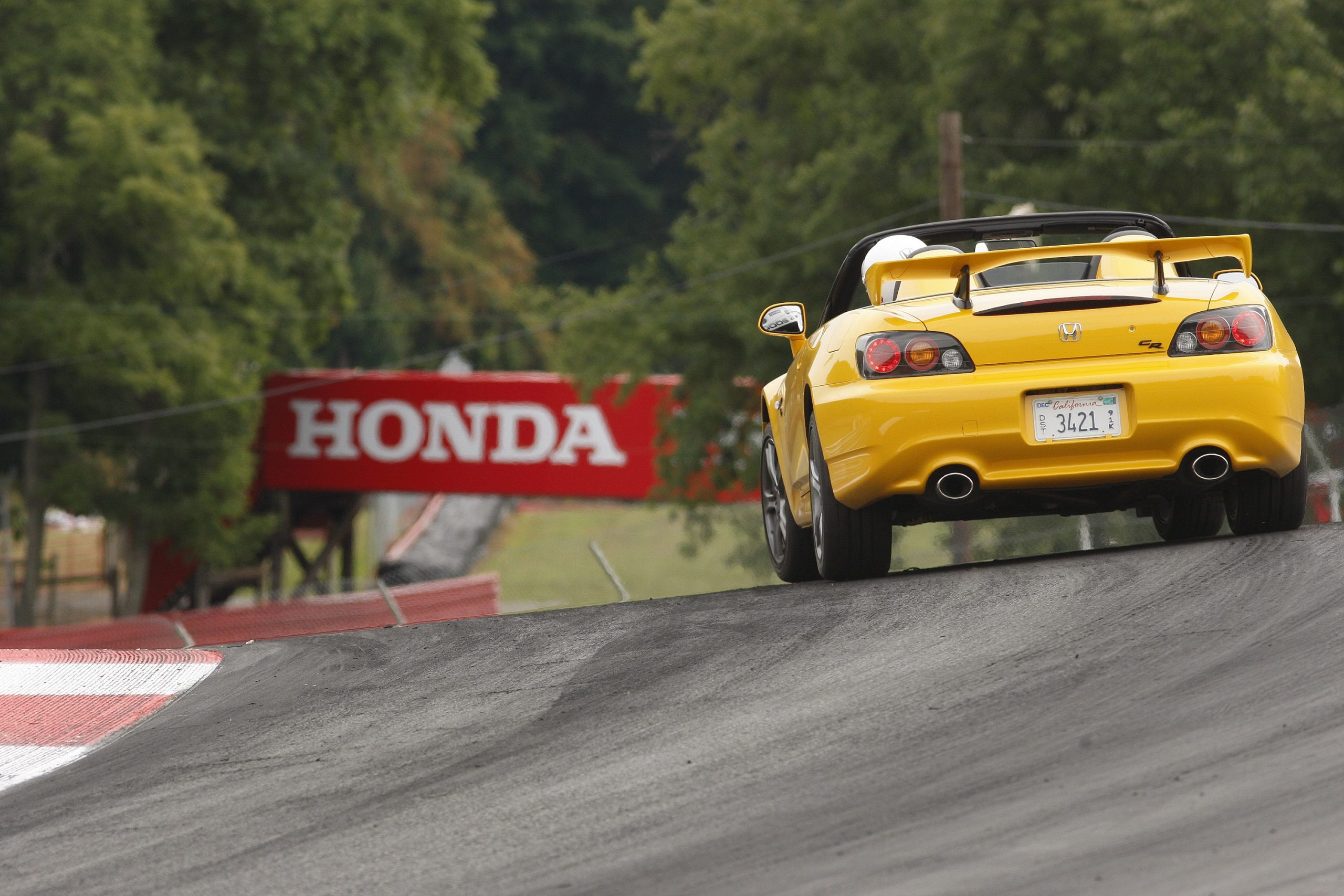A yellow S2K CR shot from the rear at a Honda-sponsored track day event