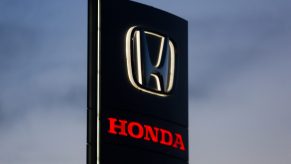 A black Honda dealership sign with Honda written in red underneath.