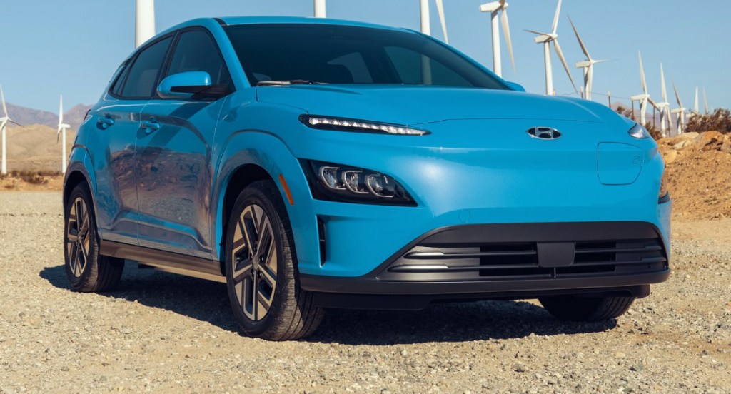 A blue Hyundai Kona EV electric SUV is parked outdoors.