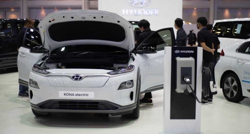 A white Hyundai Kona EV electric SUV is on display. 