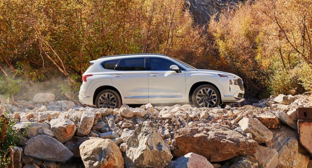 A white 2022 Hyundai Santa Fe SEL is parked atop rocks. 