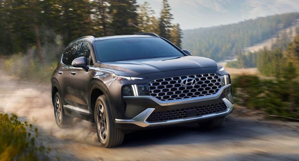 A black 2022 Hyundai Santa Fe Hybrid SUV is driving off-road.