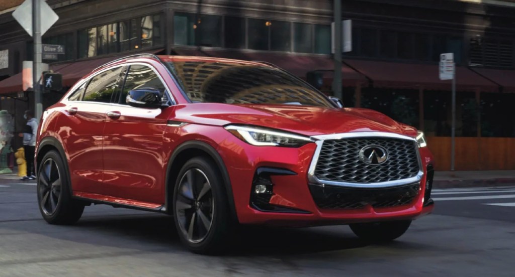 A red 2022 Infiniti QX55 is driving on the street.