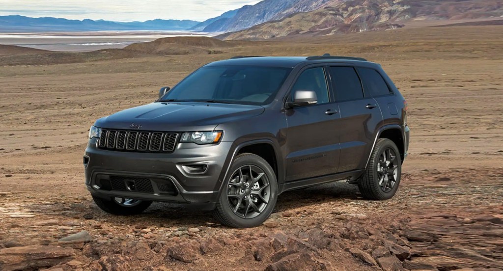 A gray Jeep Grand Cherokee is on rocky terrain.