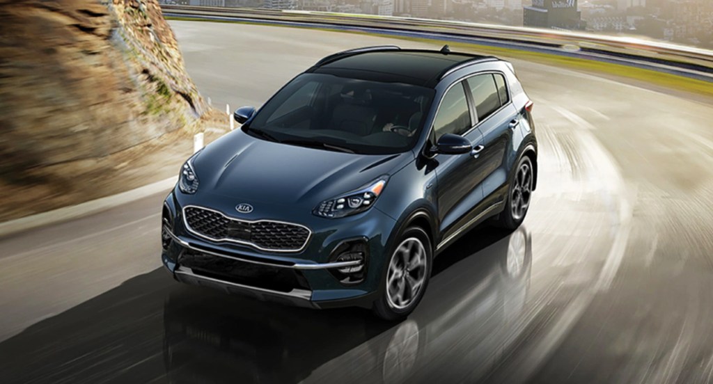 A blue 2022 Kia Sportage compact SUV is driving on the road.