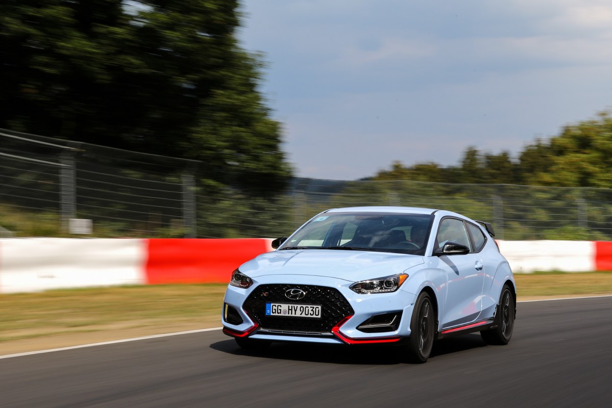 A front view of a blue Hyundai Veloster N on a race track. 
