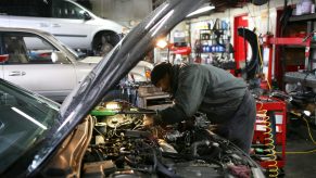 a Mechanic looks under the hood on a car. It's important to buy a reliable car.