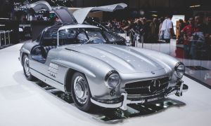 A silver Mercedes-Benz 300SL Gullwing in a showroom environment. 