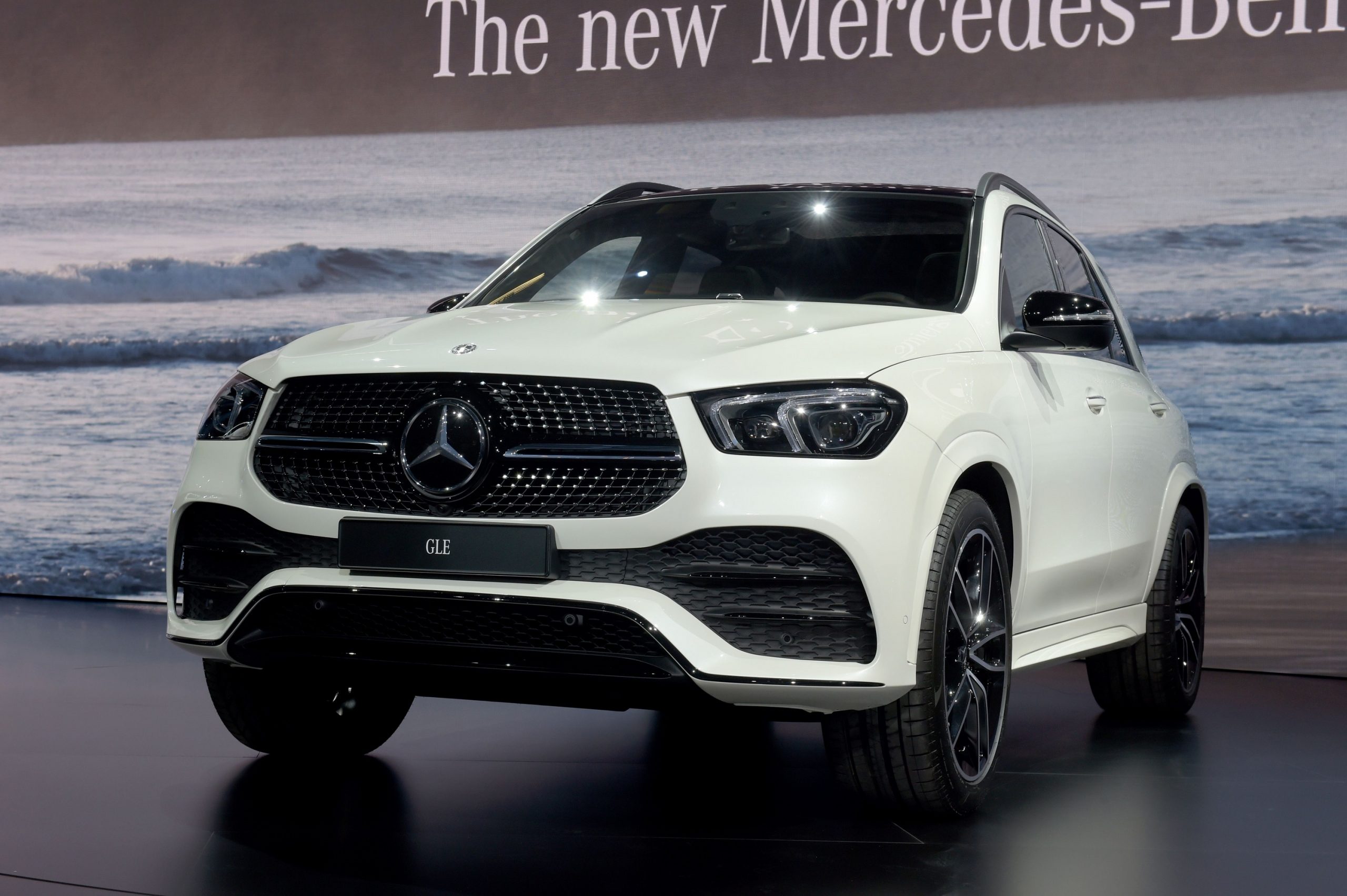 A white Mercedes-Benz GLE 450 SUV shot from the front 3/4 at the Geneva Motor Show