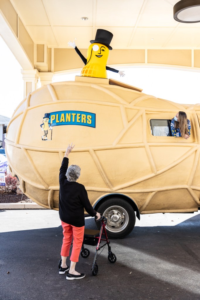 An elderly lady waves to the Nutmobile