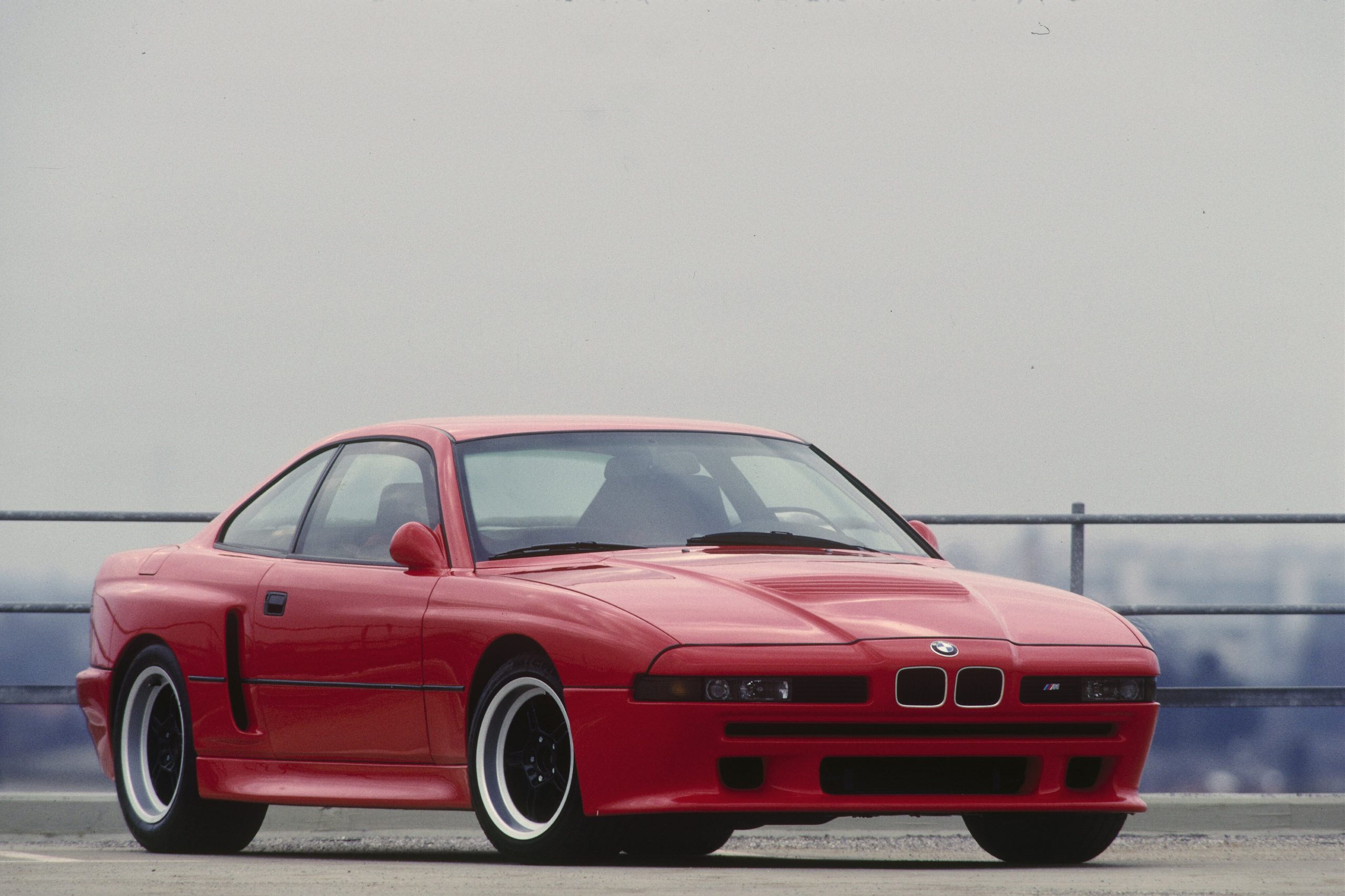 A 3/4 front view of the red E31 BMW M8 prototype.
