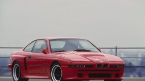 A 3/4 front view of the red E31 BMW M8 prototype.