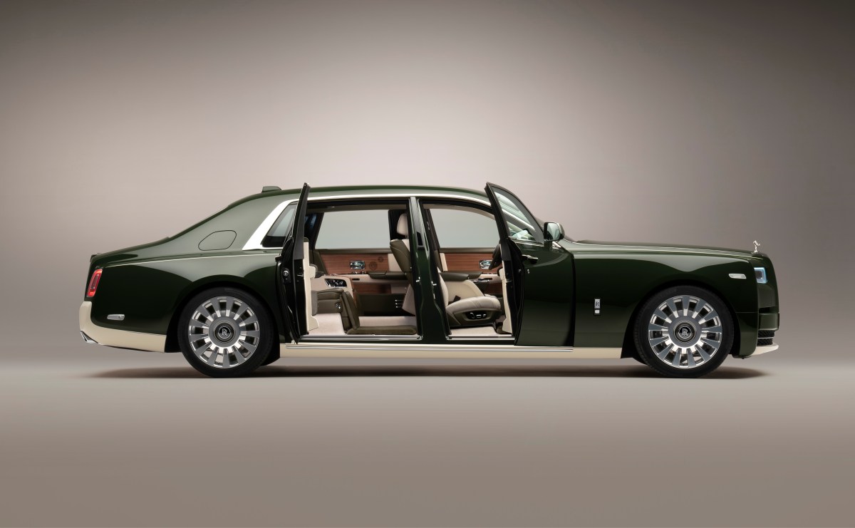 A profile view of a 2022 Rolls Royce Phantom in dark green with the front and rear doors open