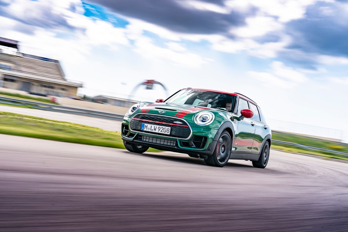 A 3/4 front view of a green MINI Cooper John Cooper Works Clubman on a race track.