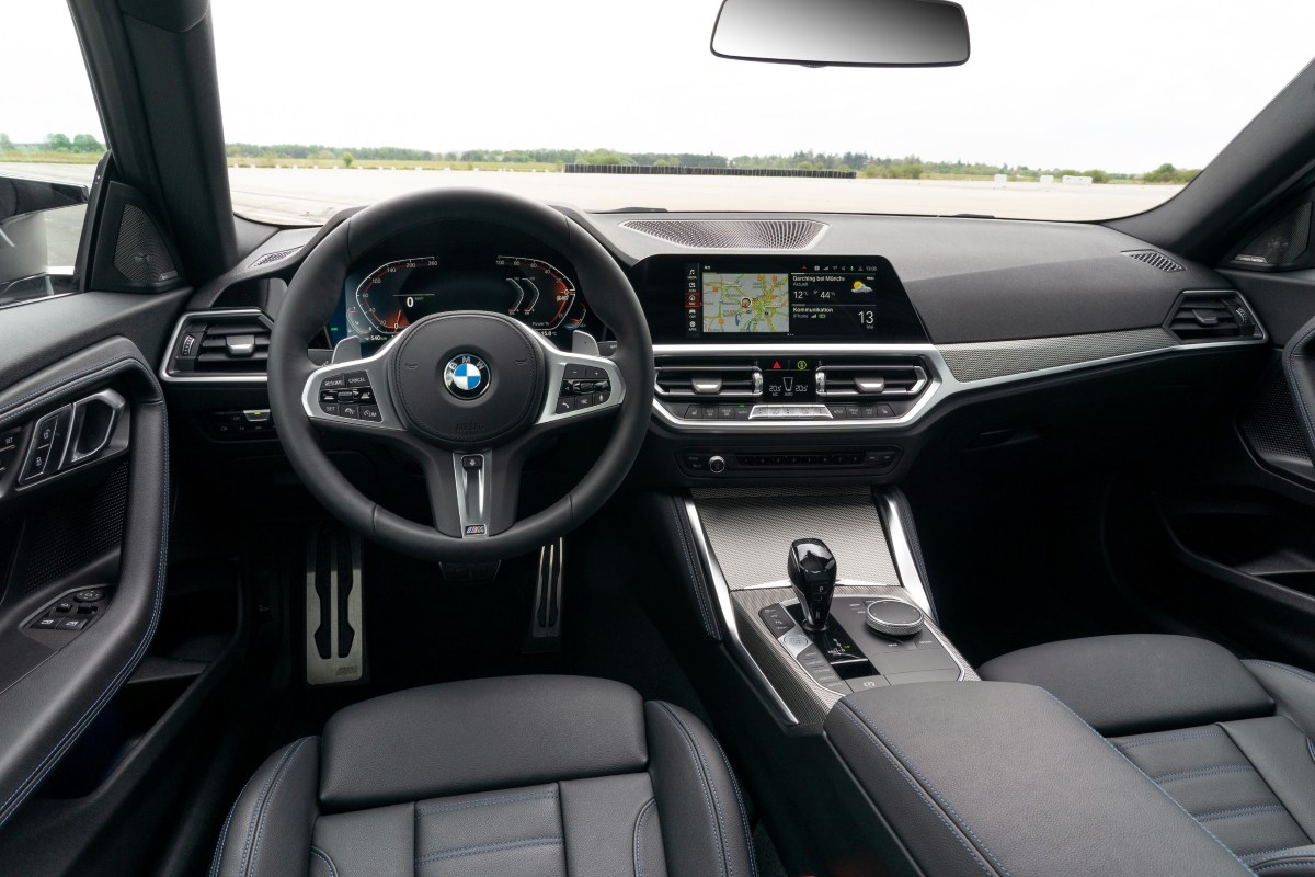A view of the interior of a 2022 BMW 2 Series coupe showing the dashboard, steering wheel and infotainment system