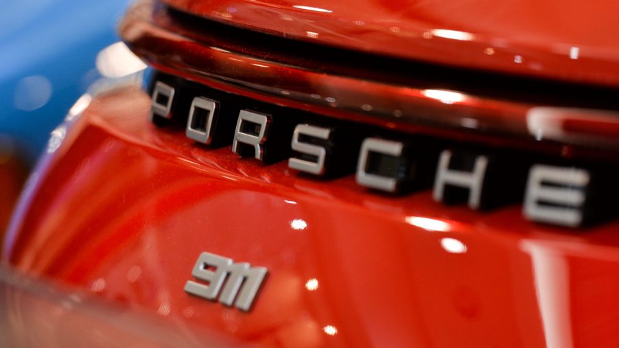 A Porsche 911 logo on the back of a red car.