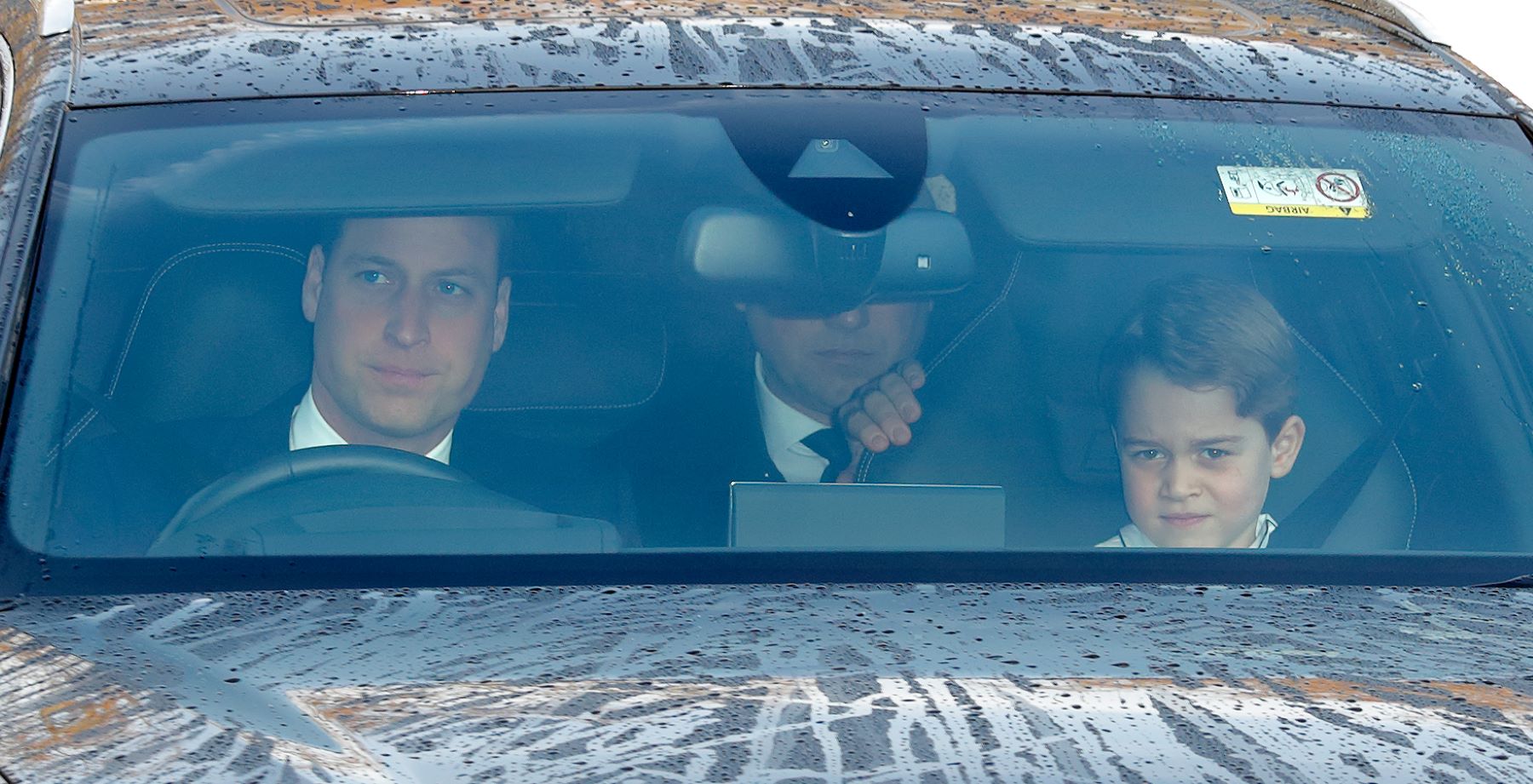 Prince William driving and Prince George in the passenger seat on the way to a Christmas lunch for royal family members in London, United Kingdom (U.K.)