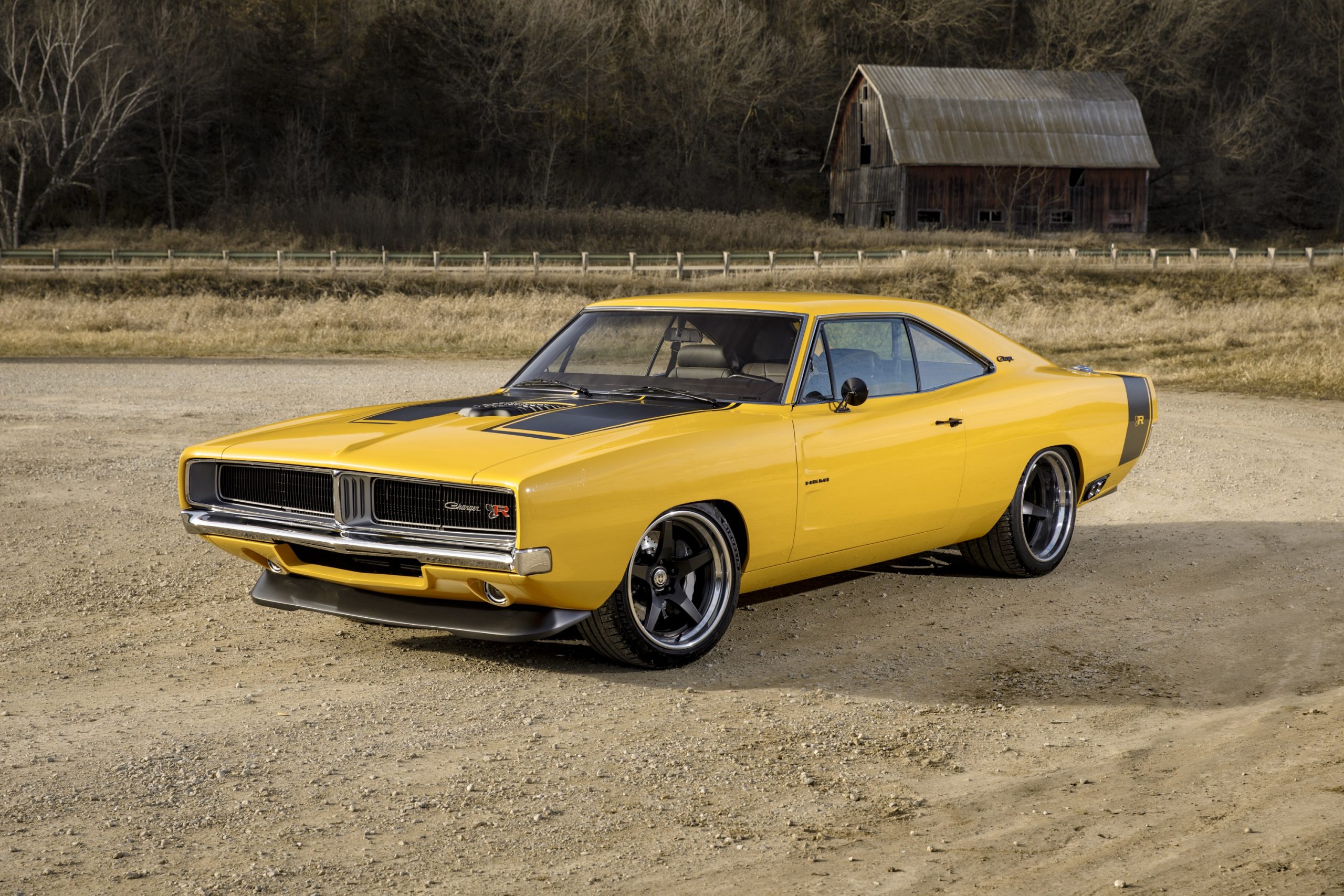 A yellow 1969 Dodge Charger restomod with a Hellcat V8 shot from the 3/4 angle
