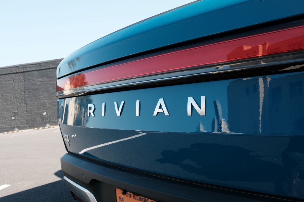 Rivian logo on a Rivian R1T pickup truck in an outdoor environment.