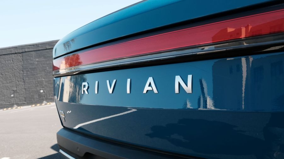 Rivian logo on a Rivian R1T pickup truck in an outdoor environment.