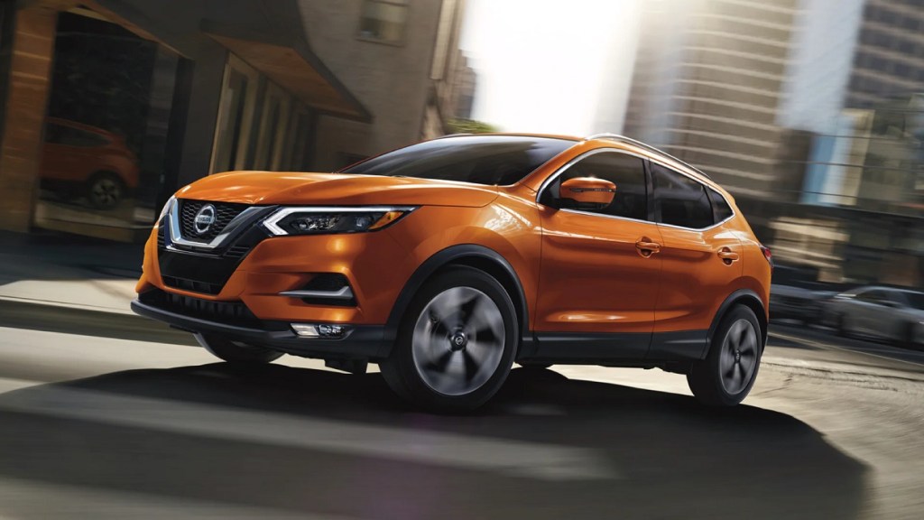An organge 2022 Nissan Rogue Sport in the city.