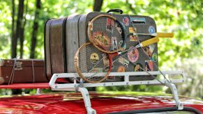 Luggage on roof racks on a red vehicle.