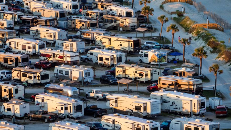Rows of RV travel trailers next to the ocean.