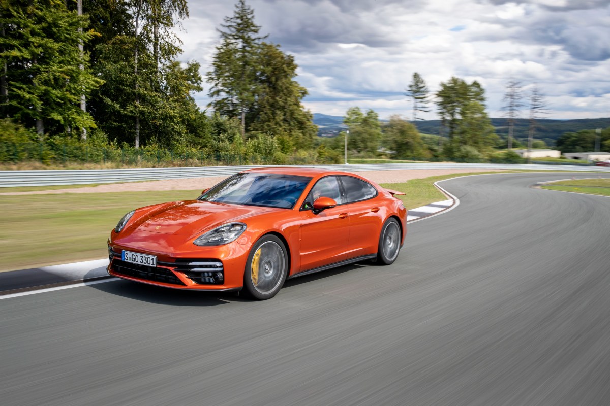 A 3/4 front view of an orange Porsche Panamera Turbo S on a race track.