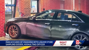 news camera footage showing black Cadillac crashed into a liquor store
