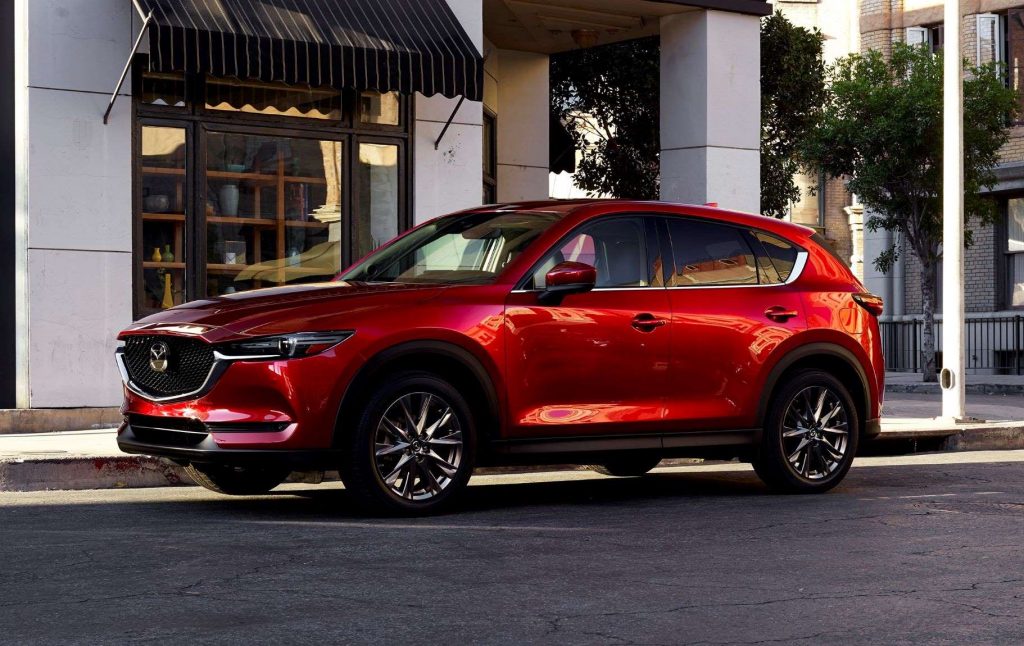 Soul Red Crystal Metallic 2022 Mazda CX-5 parked next to a sidewalk