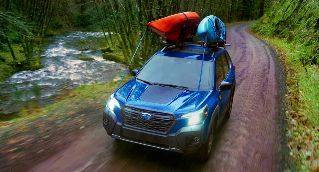 A blue 2022 Subaru Forester Wilderness is driving on a trail. 