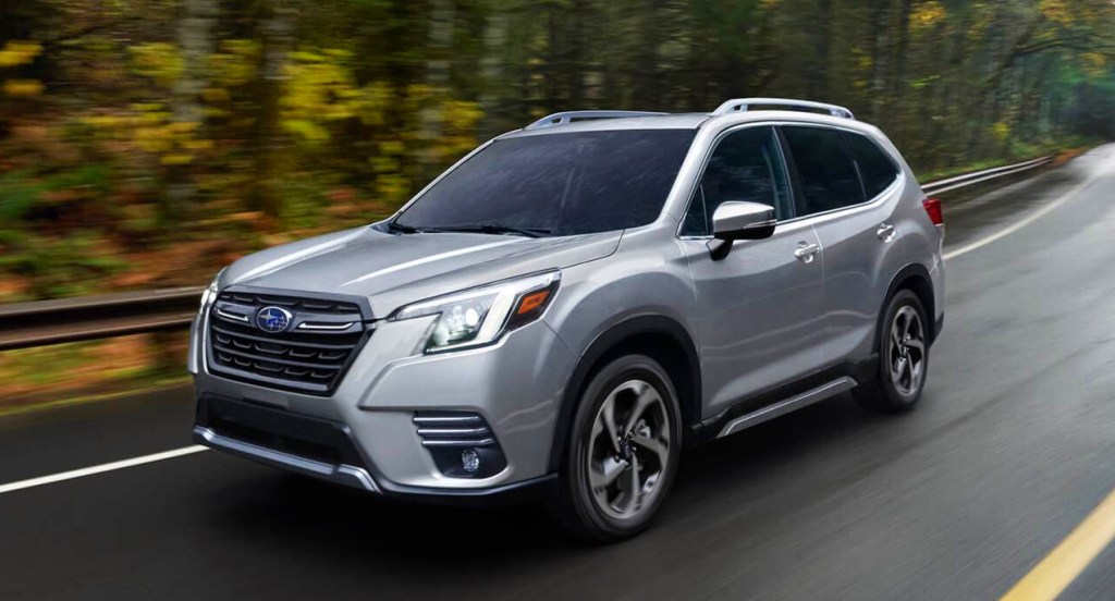 A gray Subaru Forester is driving on the road. 