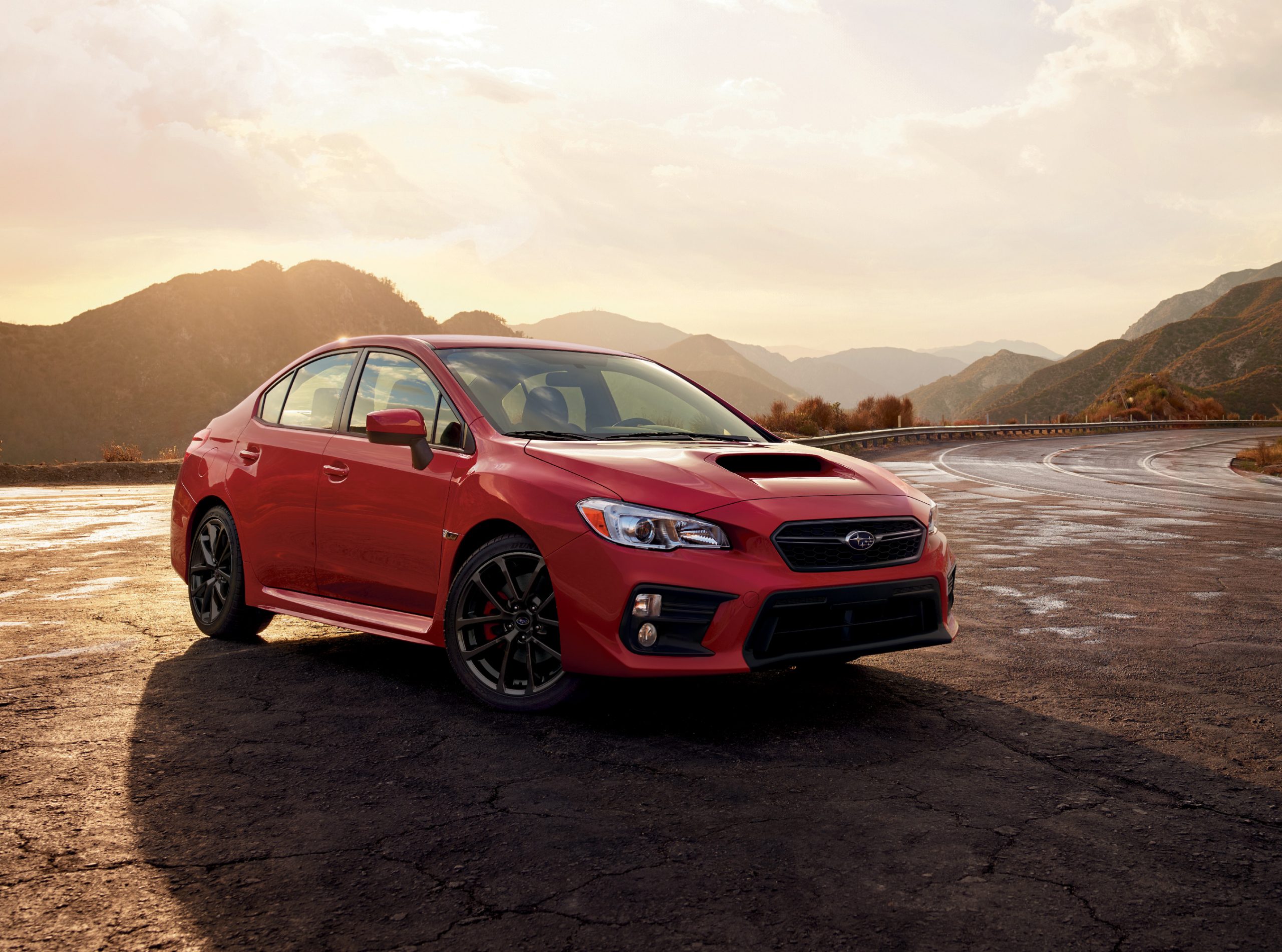 A red Subaru WRX shot at sunset. The WRX makes for an excellent cheap used car.