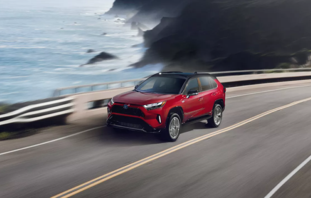 Supersonic Red 2022 Toyota RAV4 Prime driving on a coastal road