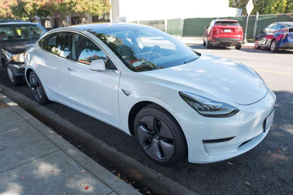 Tesla Model 3 parked by a sidewalk, highlighting story about an electric vehicle warming up a cabin in cold weather