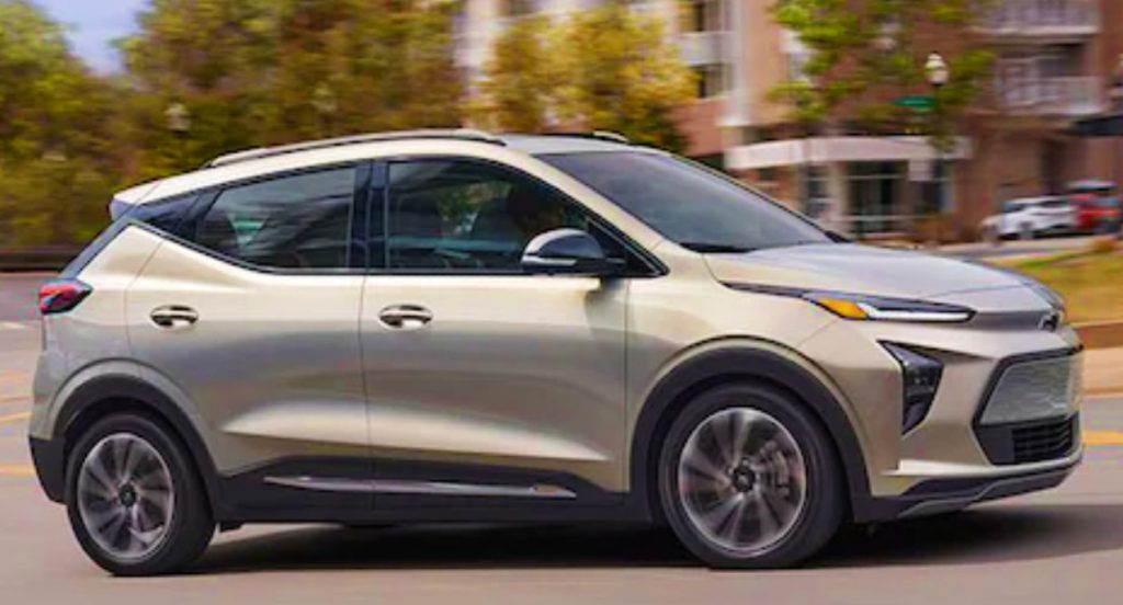 A tan Chevy Bolt EUV electric SUV is driving down the road. 