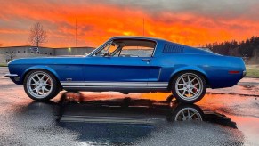 The side view of Tim Keptner's blue-and-white 1968 Ford Mustang Fastback restomod in a parking lot